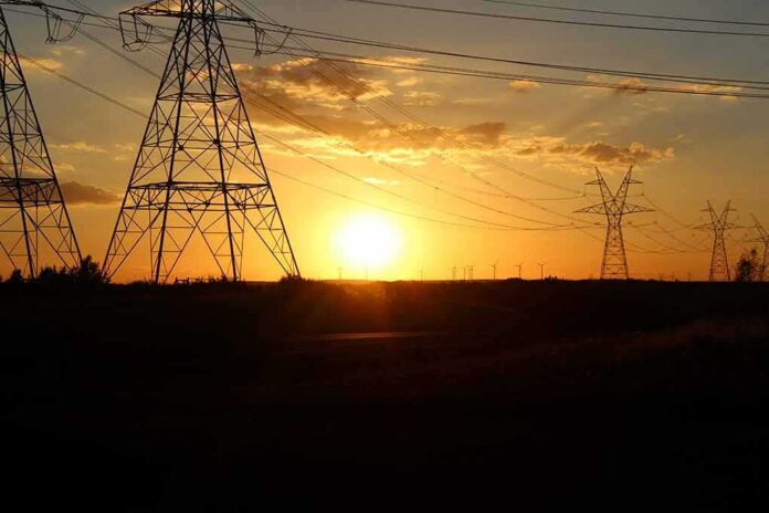Transmission towers at sunset with power lines