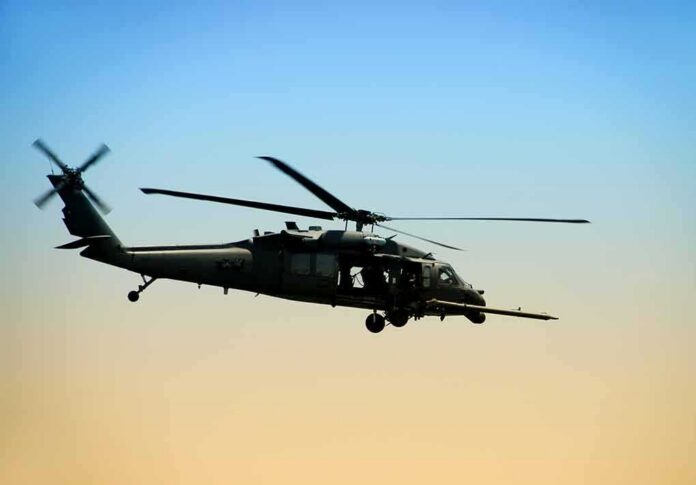 shutterstock_19379347 military helicopter flying at sunset