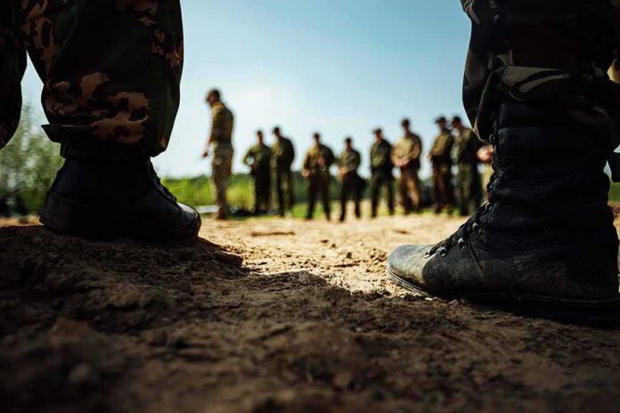 Soldiers in boots framing a group standing in a field