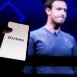 Mark Zuckerberg on screen with a hand holding a phone showing the Meta logo