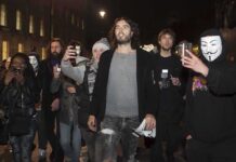 Southwark Showdown: Russell Brand On Trial Russell Brand walking with a crowd at night