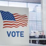 Red Stronghold Wobbles – Texas in Play Voting booth with American flag design in a modern polling place