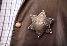 First-Ever Gang Unit Targets Explosive Surge Sheriff badge on a brown jacket