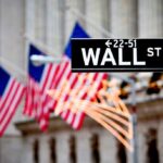 Shareholders Obliterated – Getty Handed To Koch Wall Street sign with American flags in the background