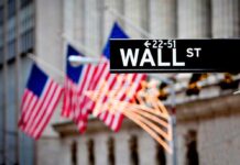 Shareholders Obliterated – Getty Handed To Koch Wall Street sign with American flags in the background
